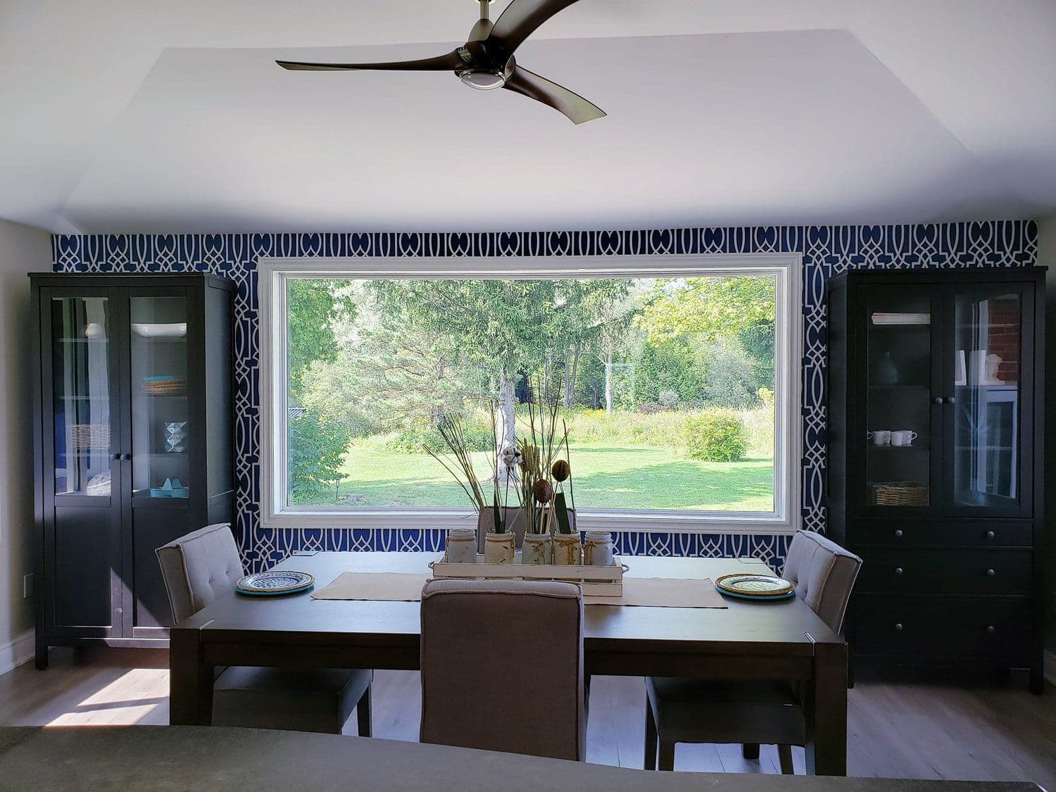 Dining area with patterned wallpaper and large picture window